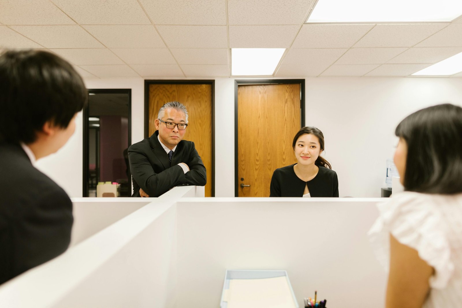 Group of business professionals in discussion within a modern, well-lit office setting.