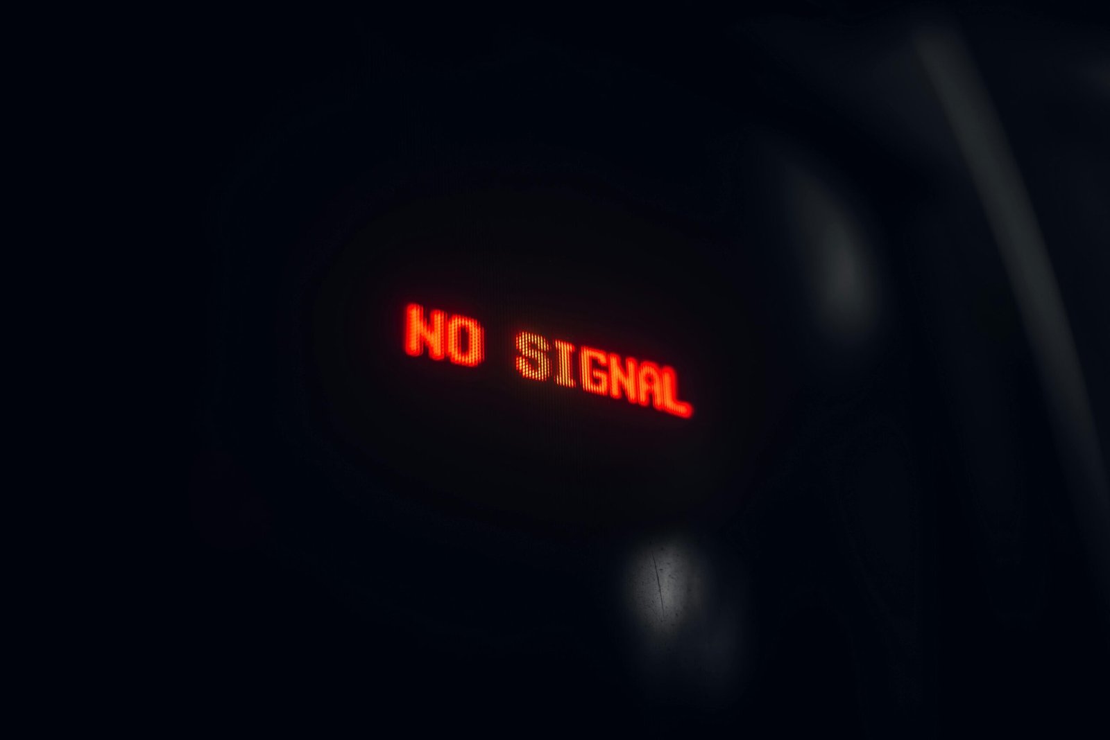 A red LED display indicating 'No Signal' in a dark setting, conveying a tech warning.