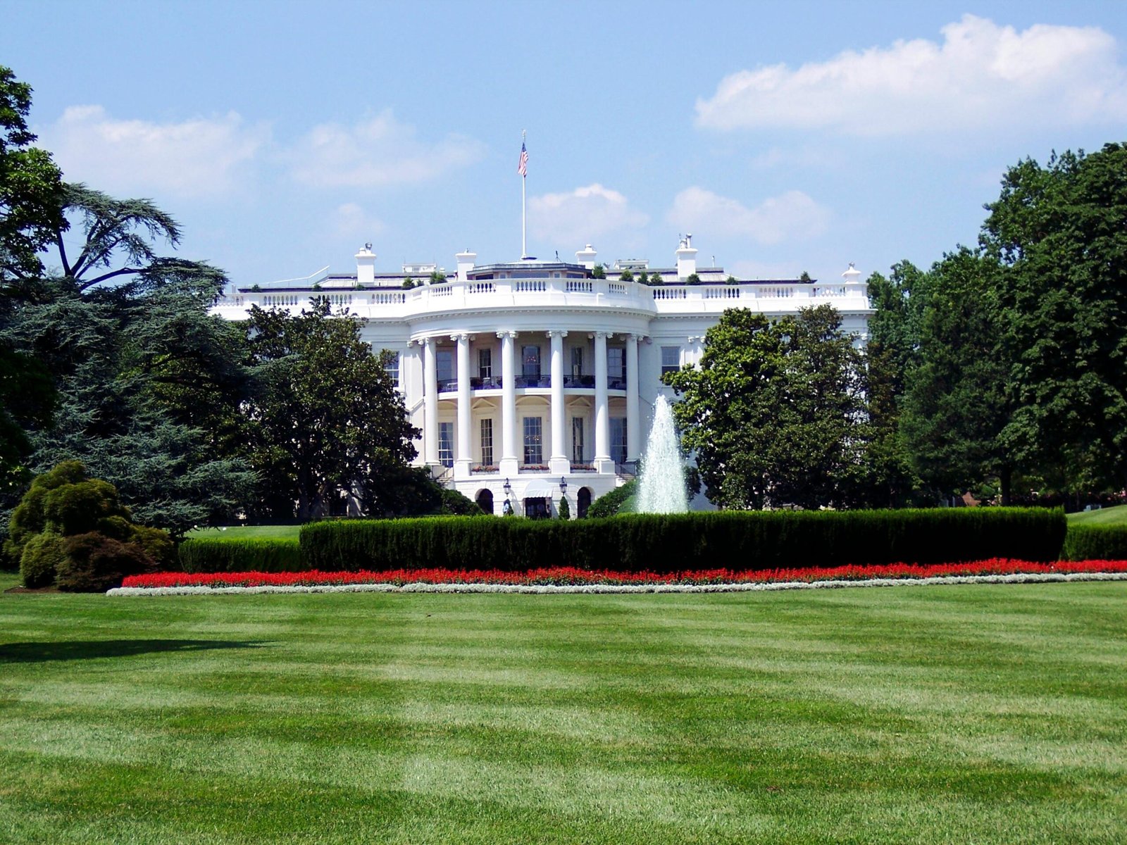 Misinformation is no longer a media problem. It is a governance problem Iconic view of the White House with lush gardens and a central fountain on a sunny day.