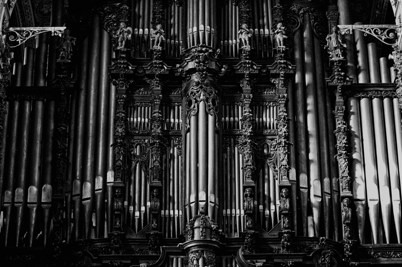Intricate gothic-style organ pipes captured in a vintage black and white photograph.